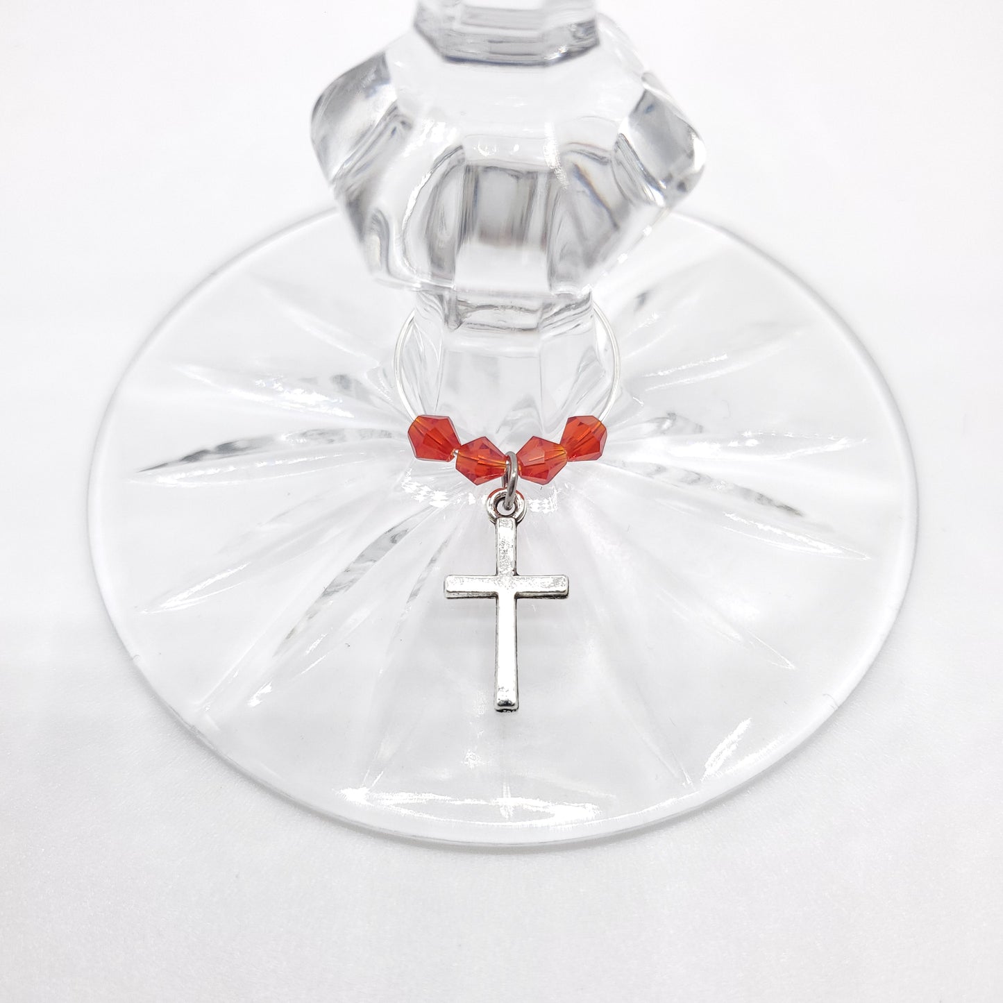cross wine charm on a glass with red crystal beads